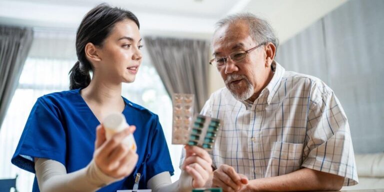 Female Nurse Staff Giving Medication to a Senior Resident of Memory Care Facility