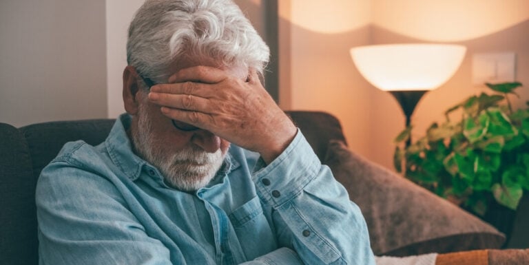 Elderly Man Sitting Alone on a Sofa at a Memory Care Facility
