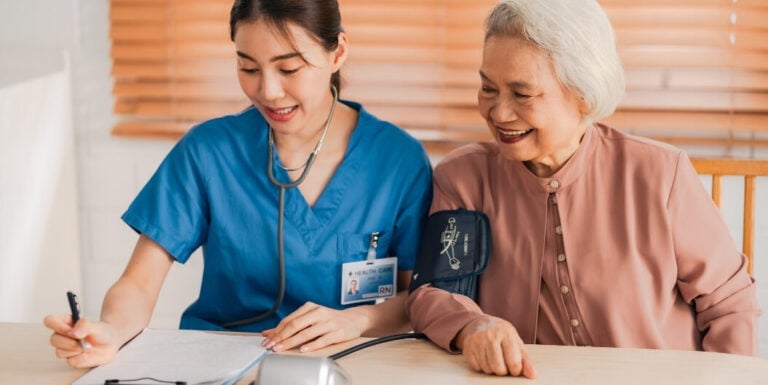 Female Nurse Checking Blood Pressure of Memory Care Facility Resident